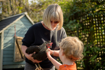 Frau und Kind mit Huhn