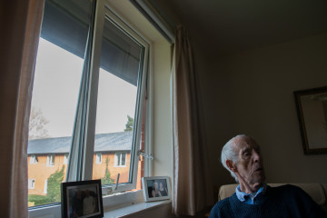 Alter Mann sitzt am Fenster