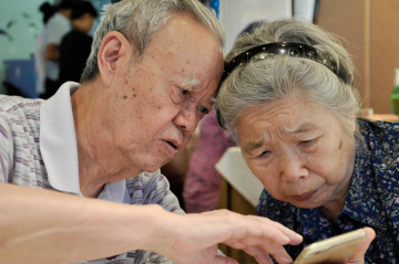 Alter Mann und alte Frau mit Handy